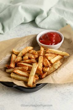 french fries with ketchup in a basket on a table