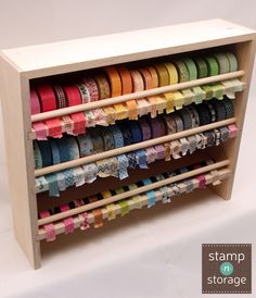 a wooden shelf with many different colored ribbons on it