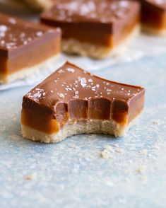 pieces of caramel and salted chocolate on a blue counter top with other desserts in the background