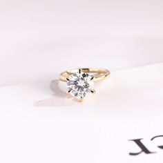 a diamond ring sitting on top of a piece of paper