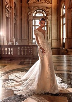 a woman in a wedding dress standing on the floor with her arms behind her back