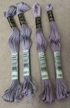 three skeins of purple yarn sitting on top of a white table next to each other