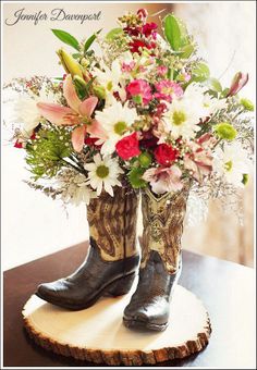 a pair of cowboy boots with flowers in them