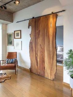 a living room with a large wooden sliding door in the center and a chair next to it