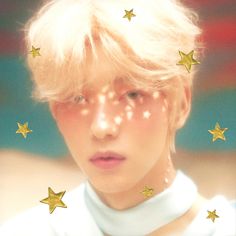 a woman with blonde hair and stars on her face is looking at the camera while she's surrounded by gold stars