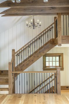 an open floor plan with stairs and chandelier