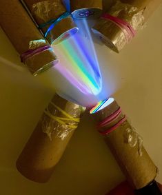 several rolls of paper wrapped in plastic wrap with colored light coming out of them on top