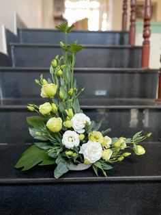 a bouquet of flowers sitting on top of a set of stairs