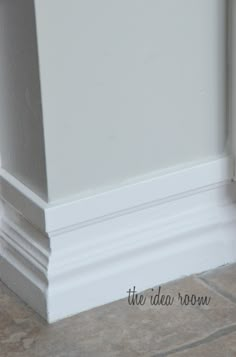 the corner of a room with white walls and tile flooring