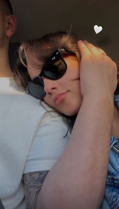 a man and woman sitting in the back seat of a car with their arms around each other