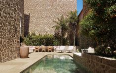 an outdoor swimming pool surrounded by stone walls