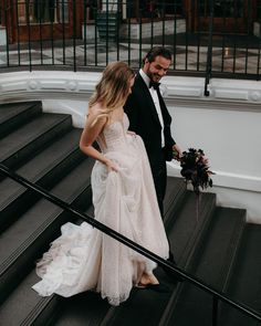 the bride and groom are walking down the stairs