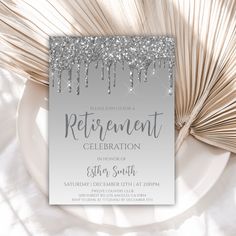 a silver glitter retirement party card on top of a white plate with palm fronds