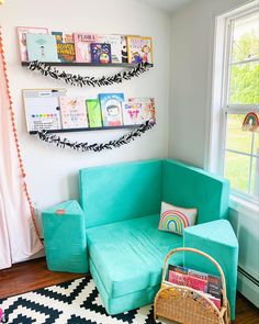 a living room with a blue couch and bookshelves on the wall above it