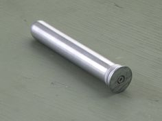 an aluminum cylinder sitting on top of a wooden table