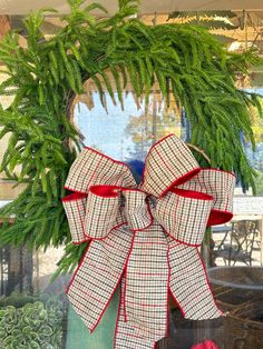 a wreath with a bow hanging on the front door