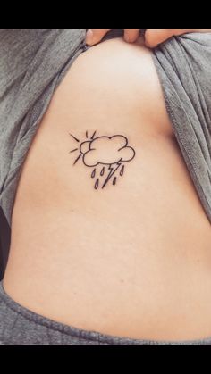 the back of a woman's stomach with a cloud and sun tattoo on it