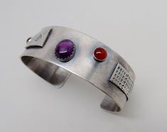 "Awesome sterling silver cuff bracelet. I formed the cuff from 18gage heavy sterling silver. A 8mm by 10 mm amethyst is at the center and 6mm garnet and 6mm citron gem stones at each side. The cuff is 3/4\"wide by 6 \" .All my jewelry come in a nice gift box." Modern Silver Gemstone Bangle, Modern Silver Bangle With Gemstone, Silver Cabochon Cuff Bracelet Gift, Handmade Silver Amethyst Cuff Bracelet, Silver Amethyst Gemstone Cuff Bracelet, Modernist Sterling Silver Cuff Bracelet As Gift, Silver Vintage Cabochon Cuff Bracelet, Artisan Silver Multi-stone Cuff Bracelet, Southwestern Multi-stone Cuff Bracelet