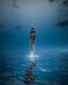 a woman is floating in the water with her head above the water's surface