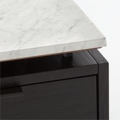 a white marble top on a black cabinet