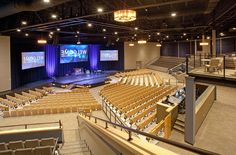 an empty auditorium with rows of seats and a welcome sign on the wall above it