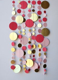 a paper mobile with circles and dots hanging from it's sides on a wall