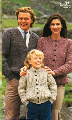 an older man and woman standing next to a young boy wearing sweaters, ties and pants