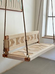 a wooden swing hanging from the ceiling in a room