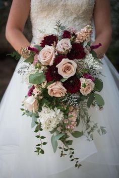 a bridal holding a bouquet of flowers and greenery