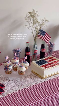 an american flag cake and cupcakes on a red, white, and blue table cloth