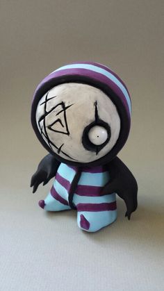 a small figurine is dressed in purple and white striped socks with a hat on