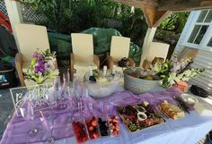 a table topped with lots of different types of food and drink glasses next to each other