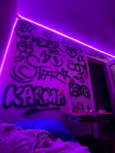 a bedroom with purple lights and graffiti on the wall