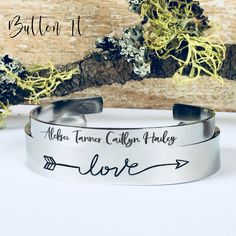 "This listing is for the SET of stainless steel cuff bracelets. This pairing of bracelets makes a great custom gift for any gal - mom, grandma, godmother, sister, friend, etc. The LOVE arrow cuff bracelet measures approximately 1/2\" by 6\". The thinner bracelet with names is approximately 1/4\" by 6\", so it will adjust to fit most wrist sizes. Both bracelets are made from 316L stainless steel which is tarnish resistant. The cuffs are a brushed satin finish on the outside , and high polished, s Names Bracelet, Love Arrow, Remembrance Jewelry, Bouquet Charms, Bracelet Stacking, Gifts For Grandma, Photo Charms, Personalized Bracelet, Personalized Grandma