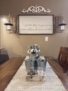 a wooden table topped with metal buckets filled with white flowers and utensils