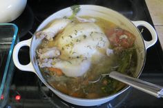 a pot filled with chicken and vegetables on top of a stove