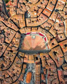 an aerial view of a city with lots of brown buildings and red roofs on it