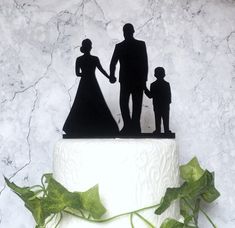 a cake with a silhouette of a man and woman holding hands on top of it