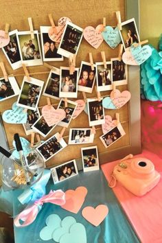 a bulletin board with pictures and hearts attached to it next to other items on a table