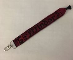 a red and black lanyard with the word bitcher on it's side