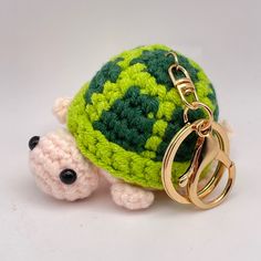 a crocheted turtle keychain with a ring on it's back