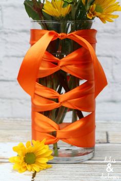 a vase filled with yellow flowers on top of a wooden table