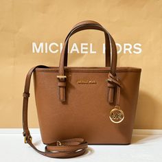 New With Tag Michael Kors Jet Set Travel Xs Carryall Tote Top Zip Satchel Shoulder Bag Saffiano Leather Brown(Luggage) 100% Authentic Retail: $448.00 Plus Tax Please See The Measurement For The Size !No Dust Bag! Gold Toned Hardware Michael Kors Logo At Front 1 Slip In Pocket At Back Zip Top Closure One Mk Charm Custom Fabric Lining 1 Zipper Pocket 9"(Top) 11"(Bottom) X 7.75" (H) X 4.25"(D) Strap: 5", 24" Very Clean, Smoke-Free And Pet-Free Environment. Casual Brown Bag With Logo, Michael Kors Casual Bags With Branded Hardware, Brown Luggage, Michael Kors Logo, Carryall Tote, Kors Jet Set, Green Leather, Zip Top, Michael Kors Jet Set