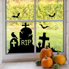 a window with halloween decorations on it and bats flying over the windowsill, next to pumpkins