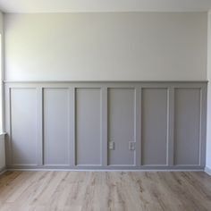 an empty room with white walls and wooden floors