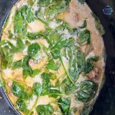 a pan filled with spinach and cheese on top of a stove