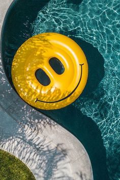 a yellow smiley face floating on top of a pool