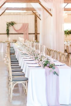 the tables are set up with white linens and purple sashers for an elegant wedding reception