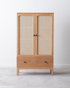 a wooden cabinet with wicker doors on the front and bottom, against a white background