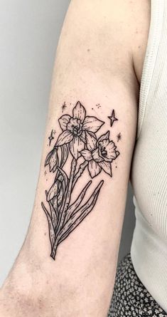 a woman with a tattoo on her arm has a flower and stars in the background